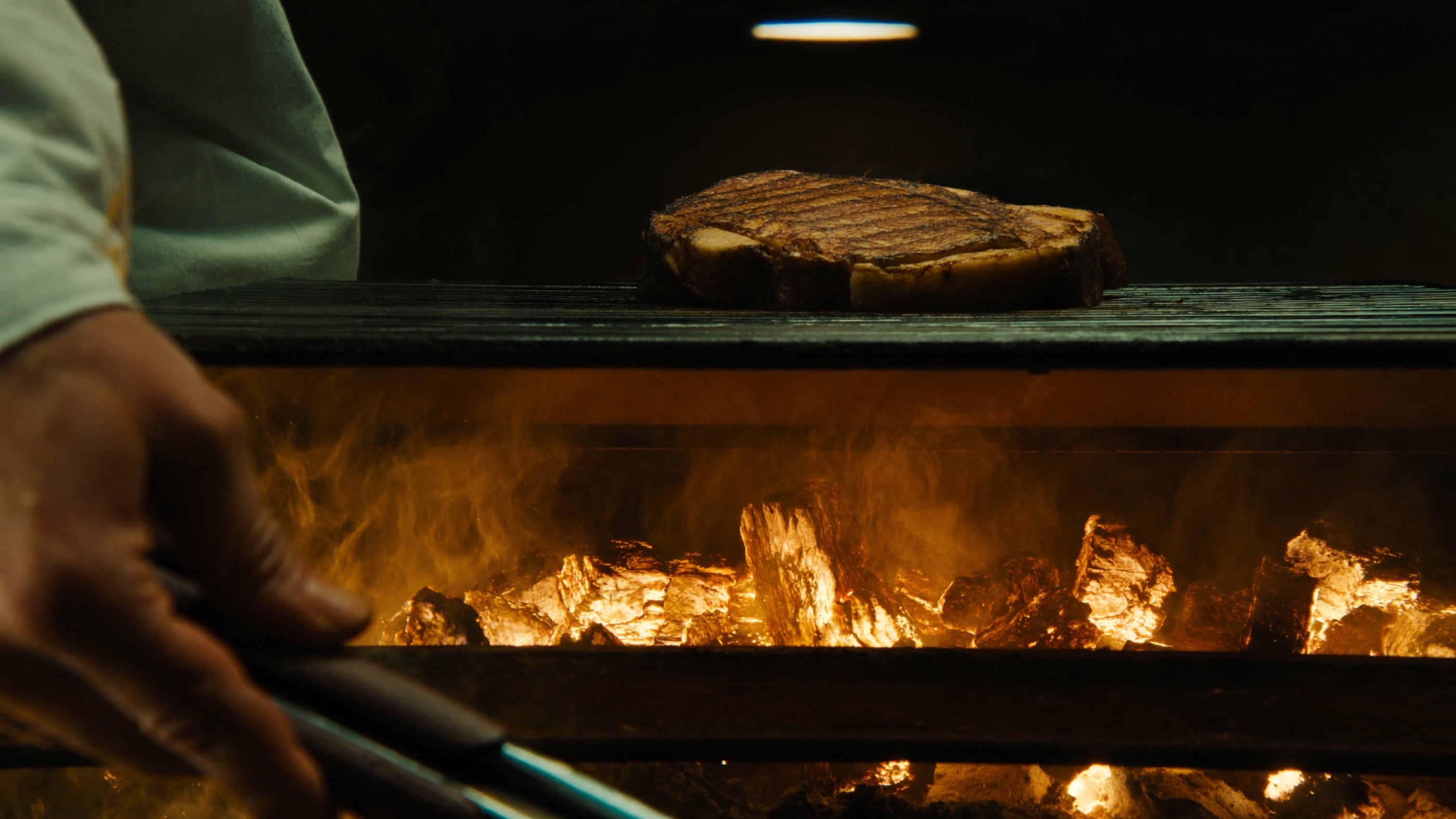 Steak T-bone · brasas alaranjadas · grelha