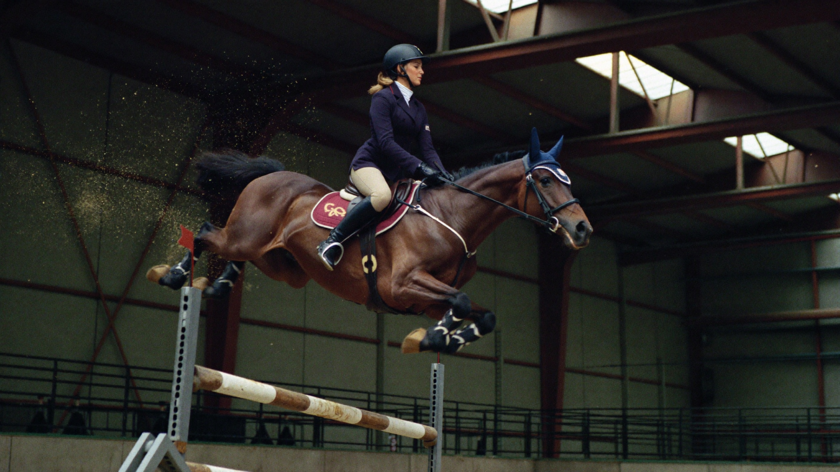 Salto na arena coberta · cavaleira sobre obstáculo