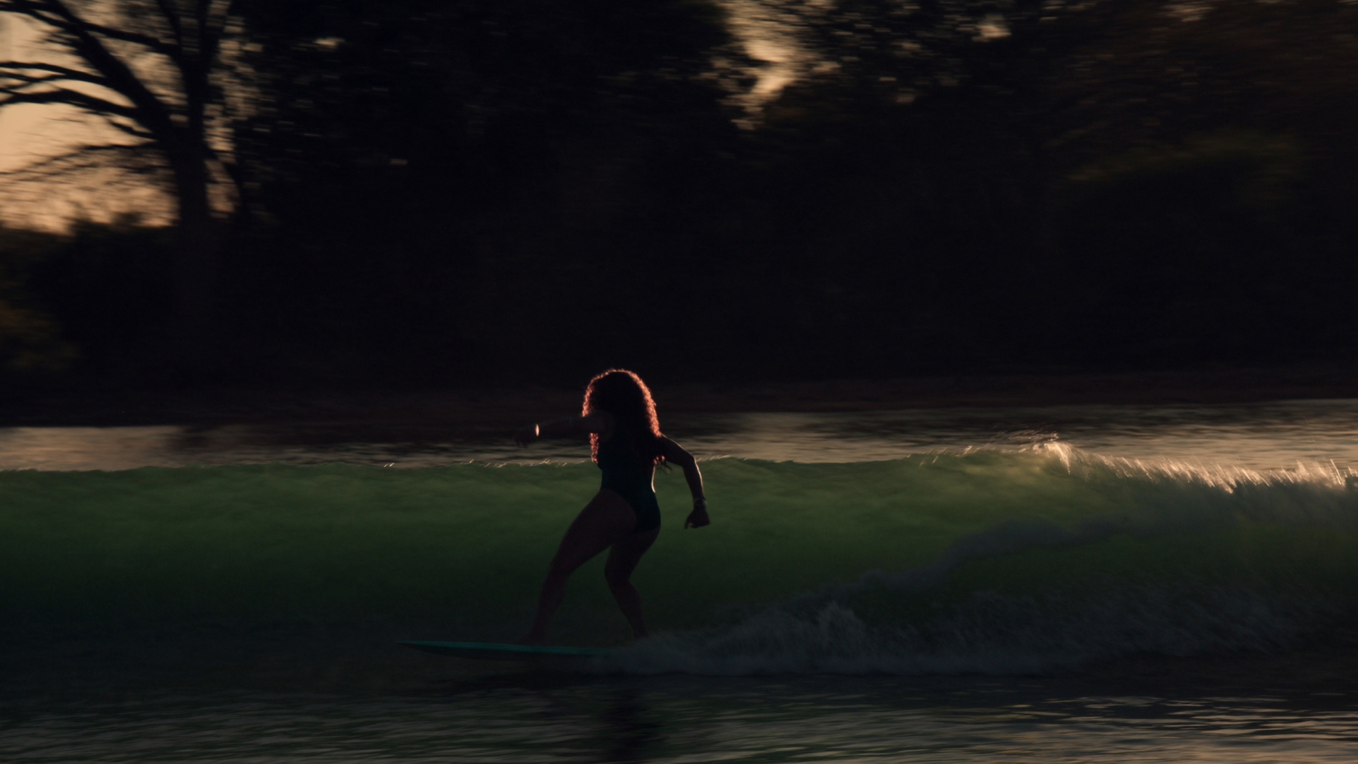 Surfista no golden hour · esteira da onda